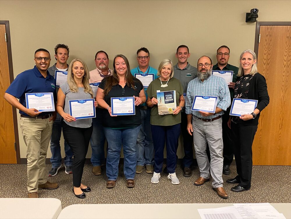 A Ten Steps certification class holding their certificates, 2022